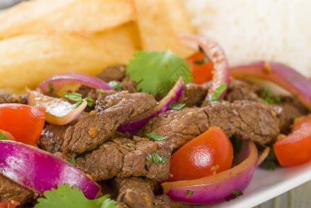 秘鲁传统炒牛肉红洋葱西红柿和薯条的搅拌油图片