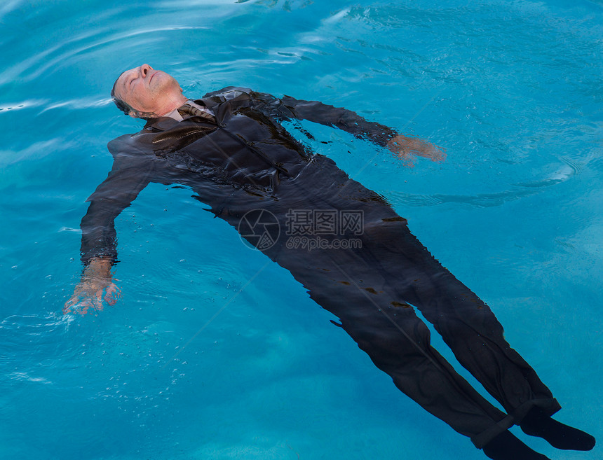 身穿西装的高级天主教商人在深蓝泳池下沉看上去像溺水一样图片
