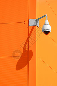 橙色墙上的安全摄像头图片