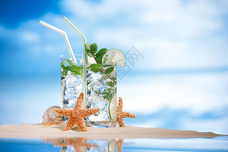 莫吉托鸡尾酒与冰朗姆酒石灰和薄荷在沙滩上的玻璃和田园诗图片