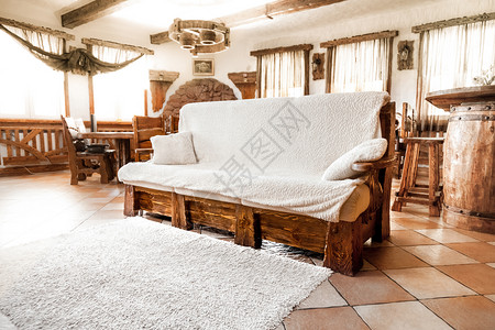 客厅里有白色毯子的大木沙发图片