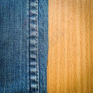 木质纹理背景上的蓝色牛仔裤图片