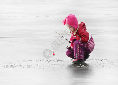冬天在结冰的湖面上钓鱼的小孩图片