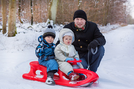 两个小兄弟姐妹和他们父亲在冬天雪图片