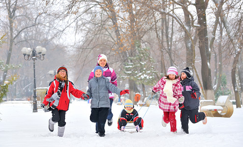 一群儿童和成人在冬天在雪地上玩耍图片