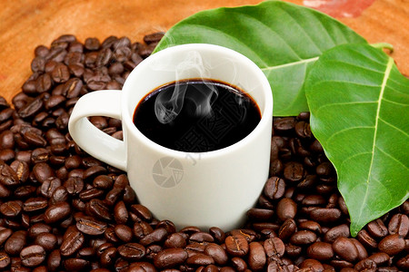 咖啡和咖啡豆在木背景图片