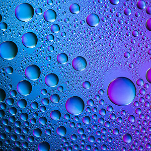 彩色水滴与梯度密封雨滴珠对玻璃盘浸渍纳米效应与运行光谱背景的蓝绿色紫背景图片