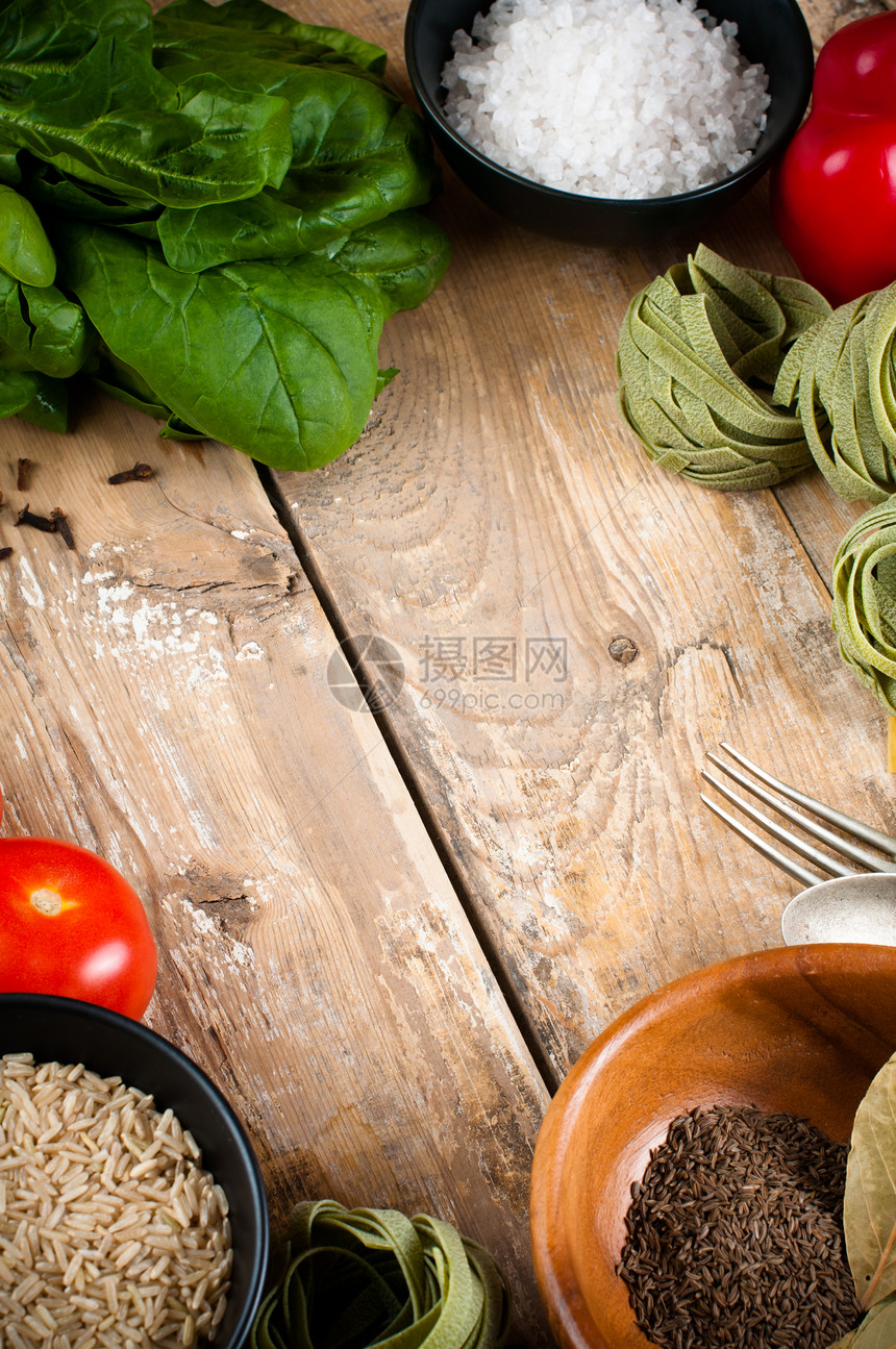 木板上的食物背景新鲜蔬菜西红柿辣椒绿色菠菜盐米饭意大利面香料和厨图片