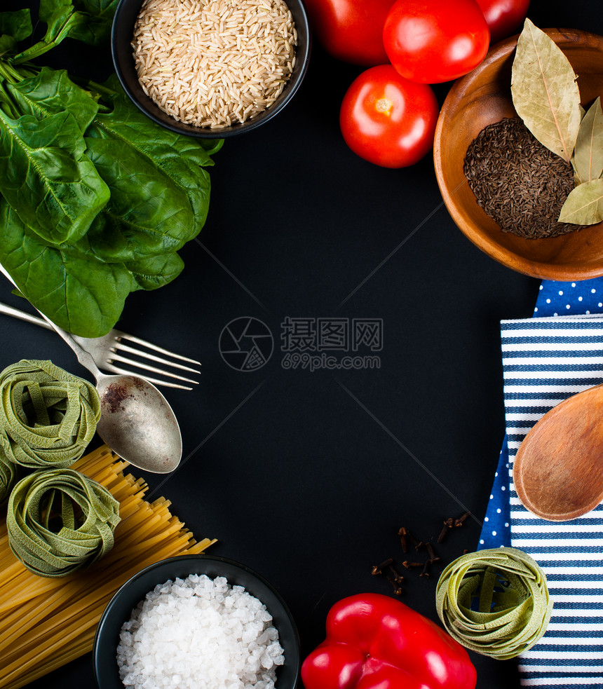 食物背景新鲜蔬菜西红柿辣椒绿色菠菜盐米饭意大利面香料和黑色背景中的厨图片