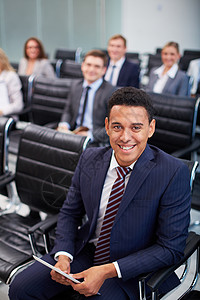 商业伙伴在研讨会上排成一排与前边微笑的男人坐图片