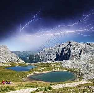 雷暴笼罩着湖泊和岩石的山地景观图片