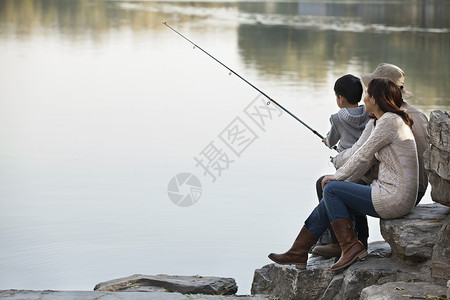 在湖边带渔具的全家福图片