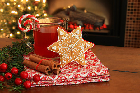 在壁炉边的圣诞饼干和热苹果酒垂图片