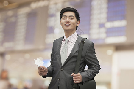 在北京机场持有机票的青年商人营业执图片