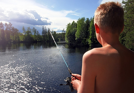 在湖边钓鱼的男孩图片