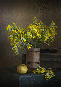 黄色的田野花在木箱上的花瓶里图片