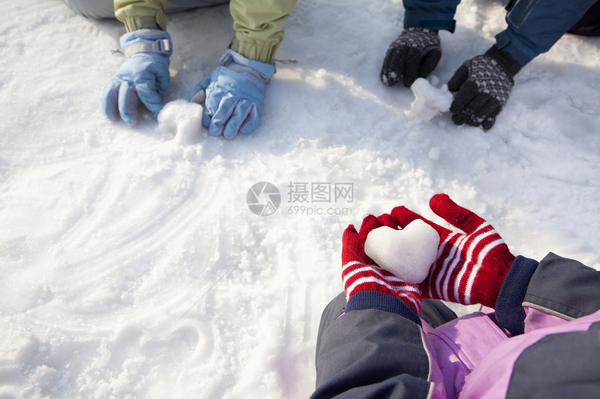 戴冬手套的手在雪地里玩耍的特写镜头图片