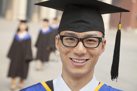 年轻毕业生有眼镜微笑背景图片