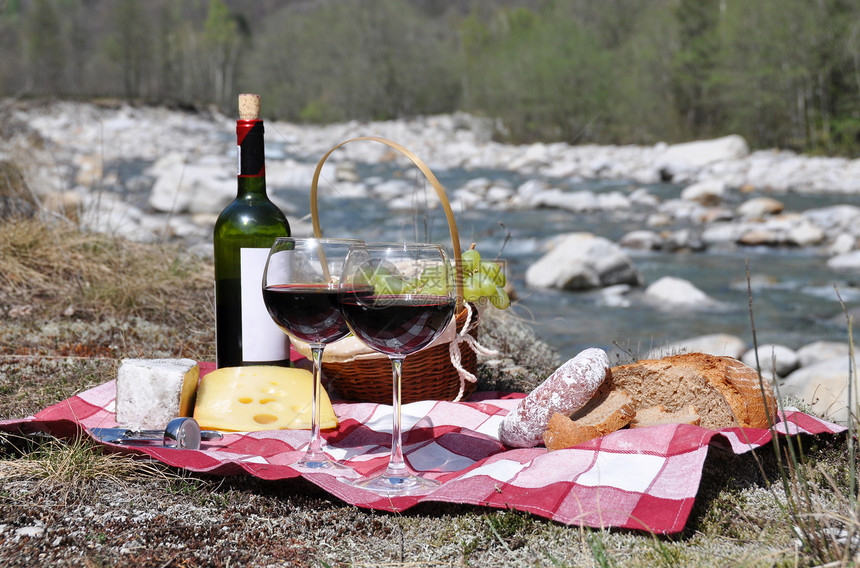红酒奶酪和葡萄在野餐时供应图片