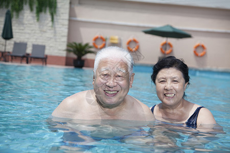 在游泳池放松的老年夫妇的肖像图片