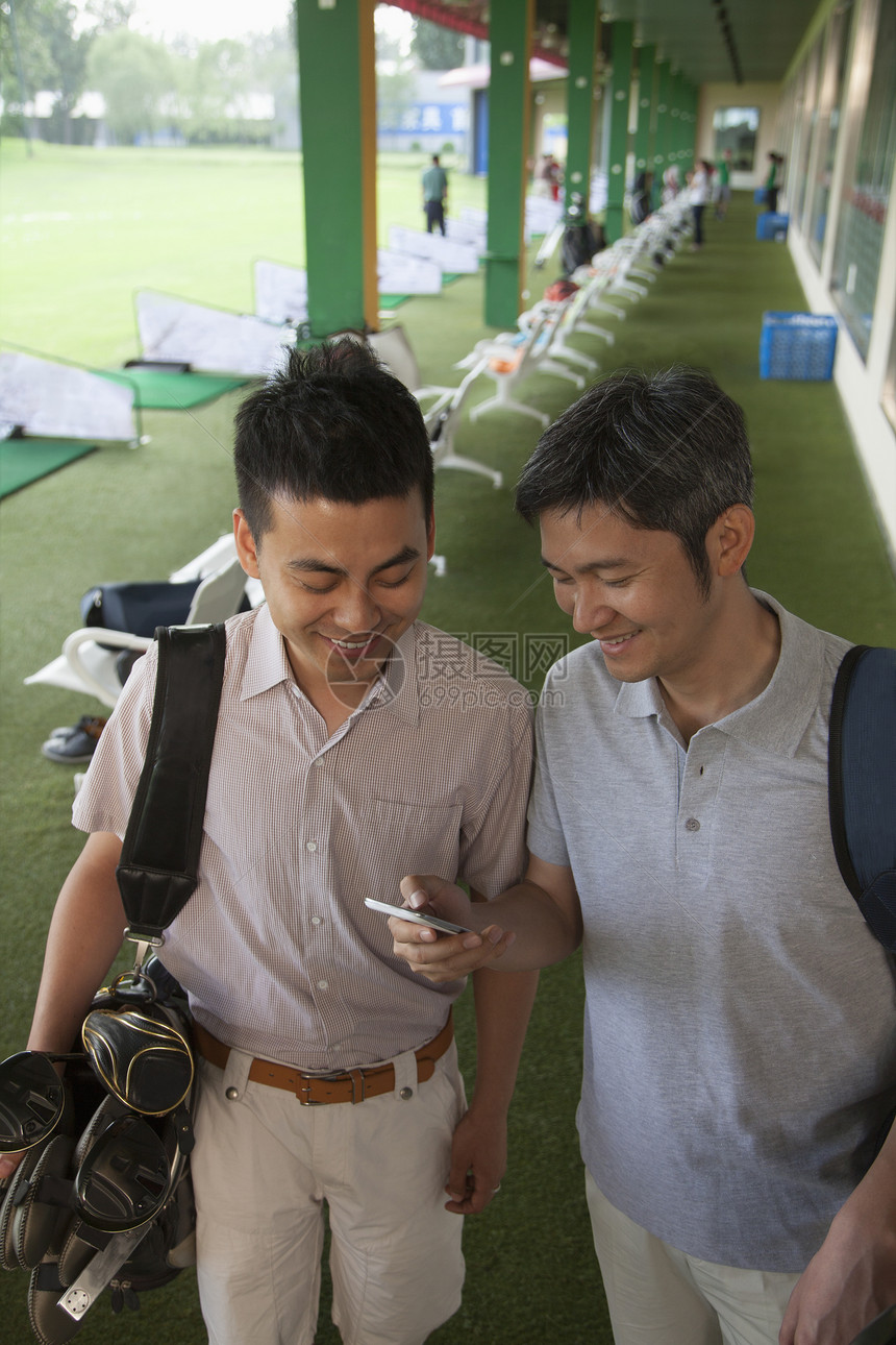 两位男朋友笑着微笑准备离开高尔夫球图片