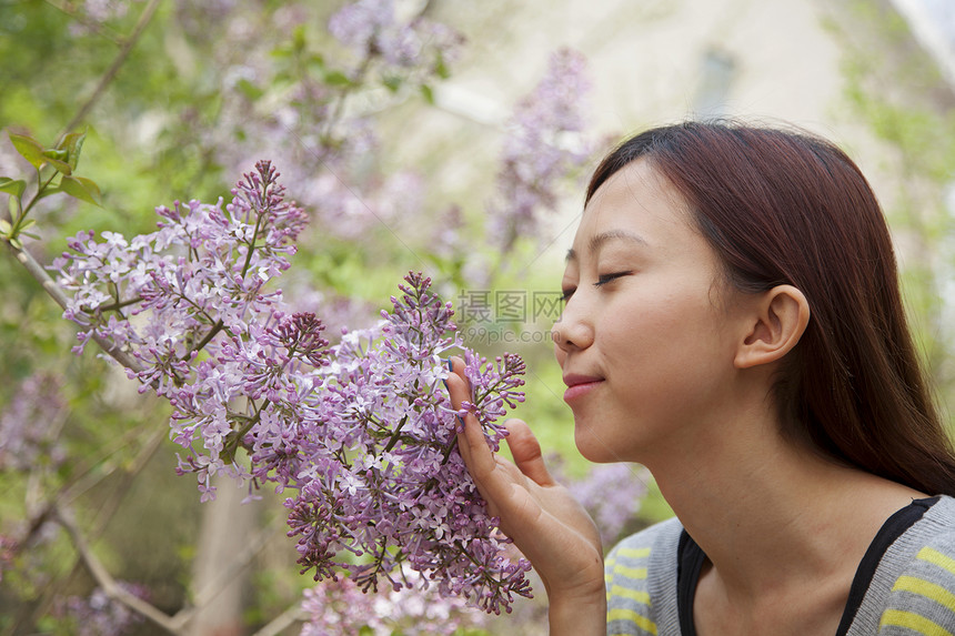 春时在公园里闻着花朵的香味眼睛闭着图片