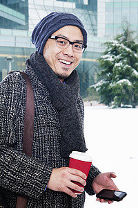 男子穿着冬季衣服手持咖啡图片
