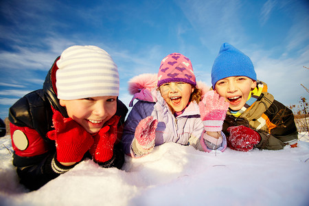 冬天穿冬装的欢乐孩子躺在雪图片