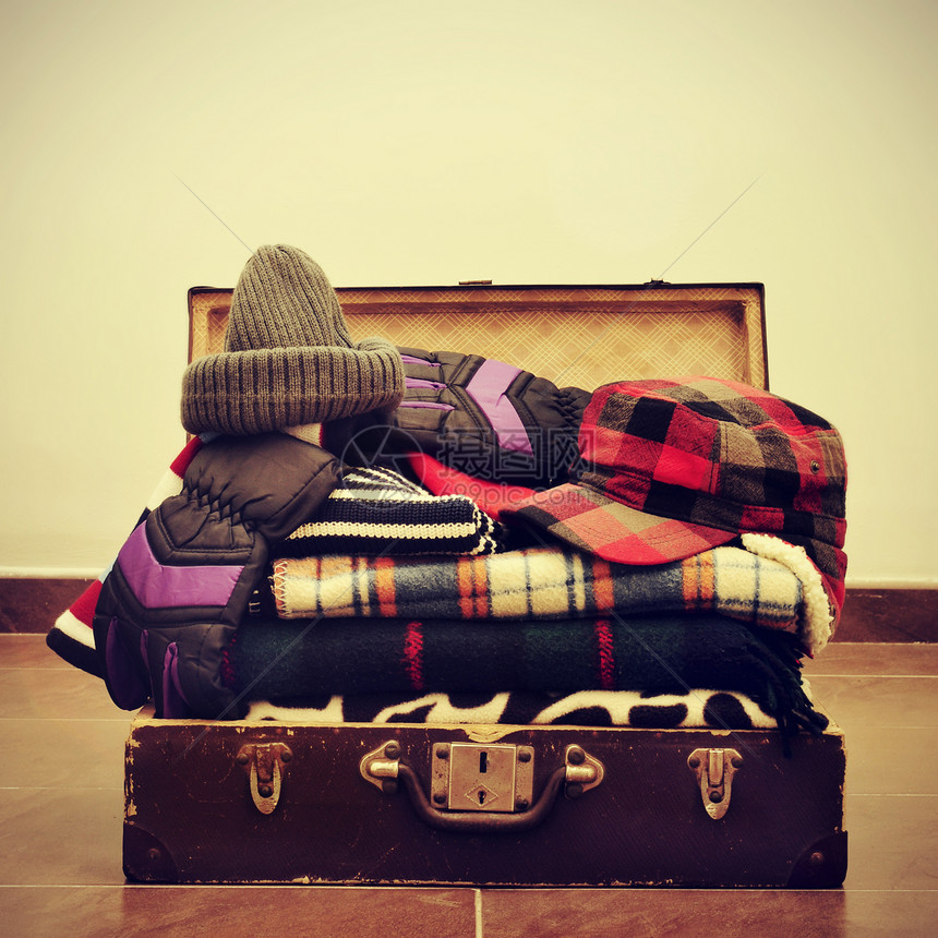 装在旧手提箱中的一堆暖化衣服图片
