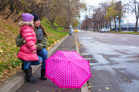 小女孩在雨天带着雨伞与图片