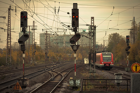 城市铁路轨道上一辆红色通班火车的图象图片