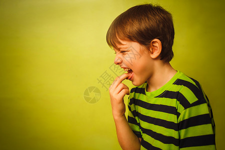 少年婴儿毒死呕吐痒在绿色背景灰色的嘴孔图片