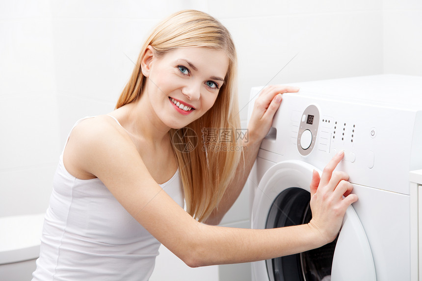 使用洗衣机的年轻美女图片