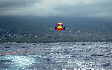 一个男人和他儿子在夏威夷上空飞翔乘着一艘船从海边拉上来的彩色图片