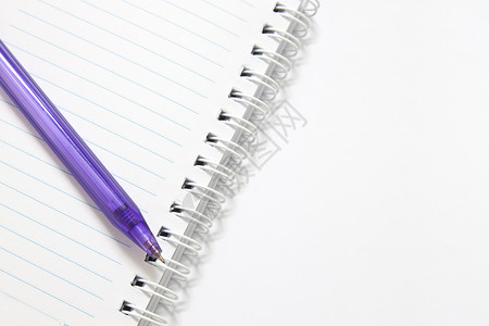 笔记本和一支紫色的笔图片