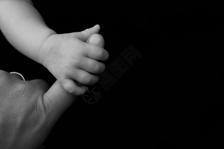 婴儿抓住她父亲的手指图片