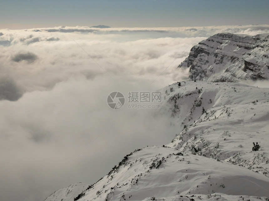 滑雪胜地山峰从低雾中涌现出来图片