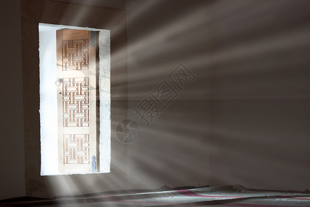 光线从敞开的门进入一个黑暗的空房间图片