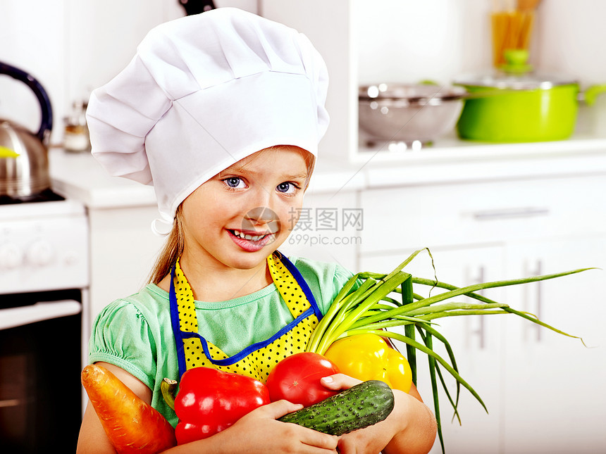 孩子在厨房里拿着蔬菜图片