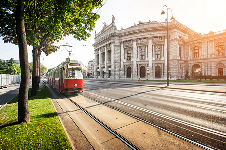 著名WienerRingstrasse的美丽景象与具有历史意义的Burgtheater最高法院剧以及奥地利维也纳日落时背景图片