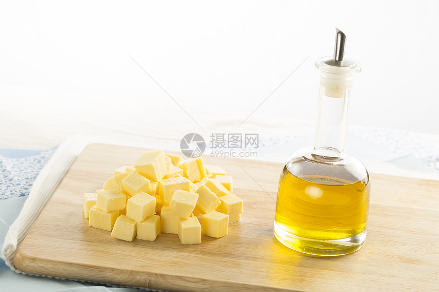 装在瓶子和奶油立方体中的橄榄油在图片