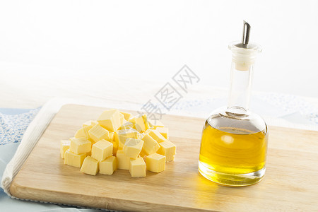装在瓶子和奶油立方体中的橄榄油在图片