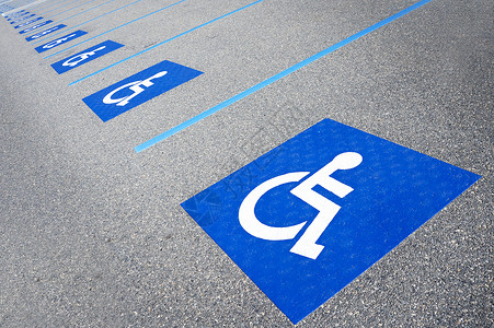 国际残疾人标志在购物中心停车位上涂有亮蓝色的字样图片