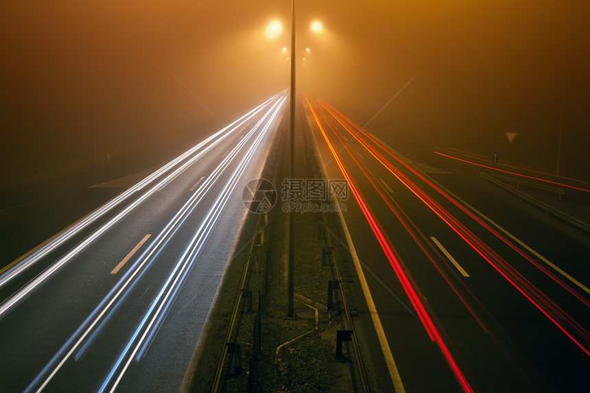 在迷雾之夜有汽车灯光路迹的高速公路上图片