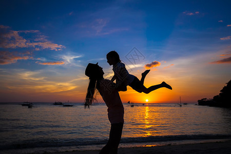 小女孩和她妈在日落时在菲律宾博拉图片