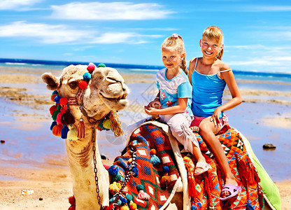 在埃及海滩上骑骆驼的游客孩子图片