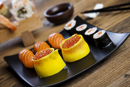 寿司加鲑鱼虎虾和鲑鱼罗在黑盘图片