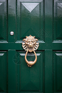 带有金狮特写形式的门环的绿色木门图片