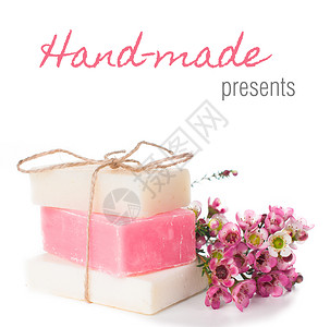 白色和粉红色的手工肥皂和白色背景上的粉红色樱花图片