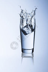 水玻璃飞溅威利杯冰块冷饮用水解渴饮食健康自来水矿泉水瓶装水蓝色背景图片